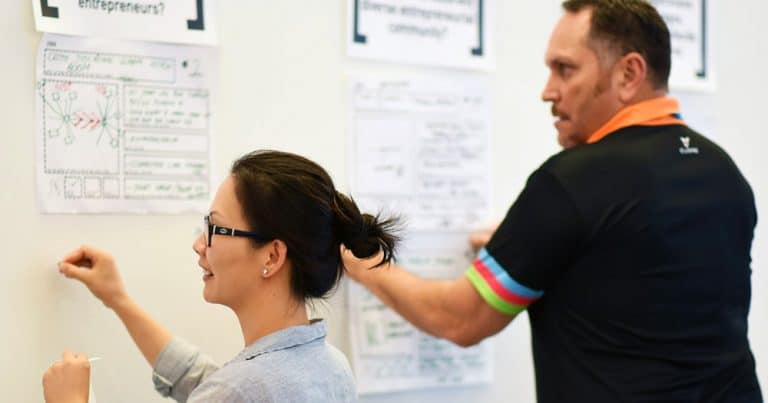 Man and woman make numerous notes on board