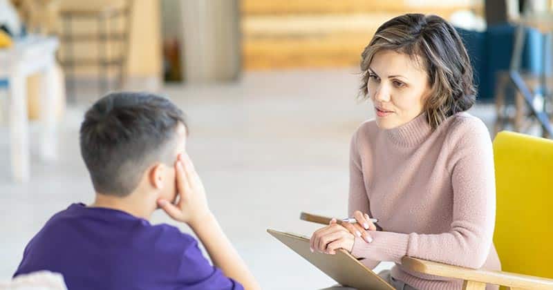 Female school counsellor working one-on-one with boy