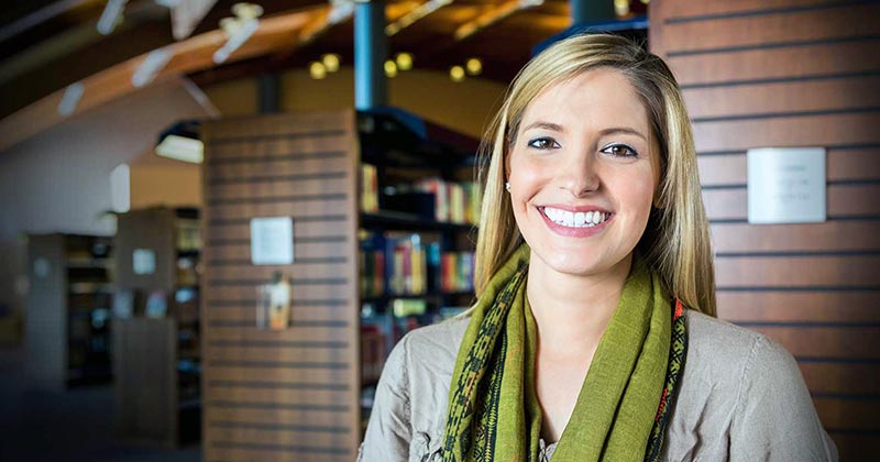 Pleasant young woman smiling in city area